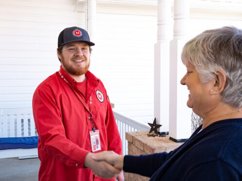 Miller's services technician shaking hands with an elderly woman