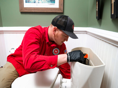 Miller's Services plumber fixing a toilet