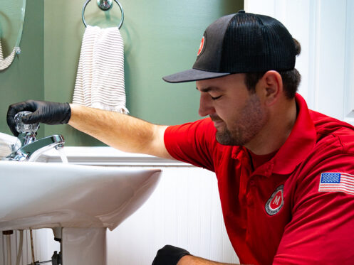 Miller's services plumber repairing a bathroom sink drain
